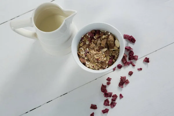 Cuenco de cereales de desayuno con frutas secas y jarra —  Fotos de Stock