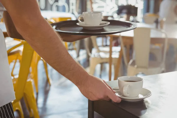 Beskurna hand av servitör serverar kaffe — Stockfoto
