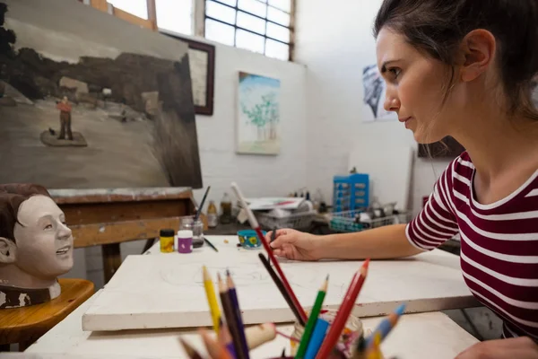 Mujer dibujando sobre lienzo en clase de dibujo — Foto de Stock