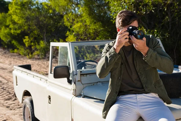 Man fotograferar medan du sitter på fordonet huva — Stockfoto