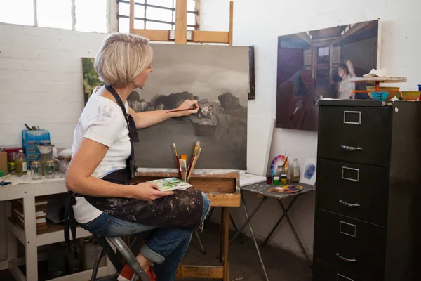 Kobieta, malarstwo na płótnie w klasie rysunkowej — Zdjęcie stockowe