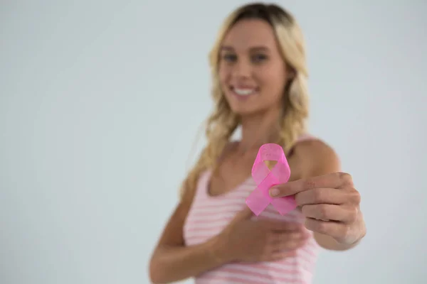 स्तन पर हाथ वाली महिला गुलाबी रिबन दिखाते हुए — स्टॉक फ़ोटो, इमेज