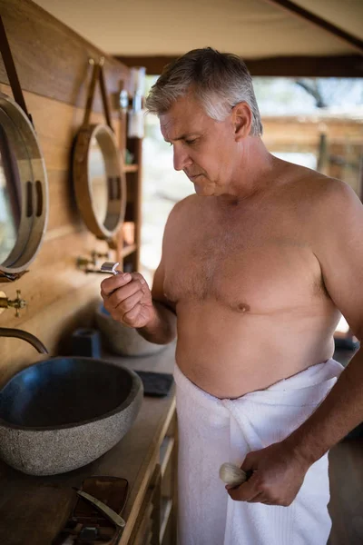 Hombre mirando navaja en casa de campo — Foto de Stock