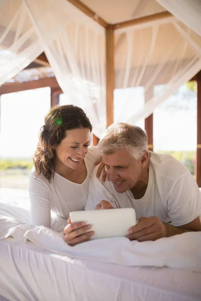 Pareja usando tableta digital en la cama — Foto de Stock