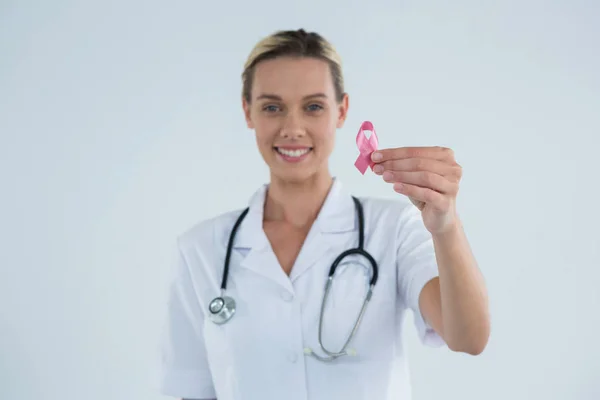 Médico feminino mostrando fita de conscientização do câncer de mama — Fotografia de Stock