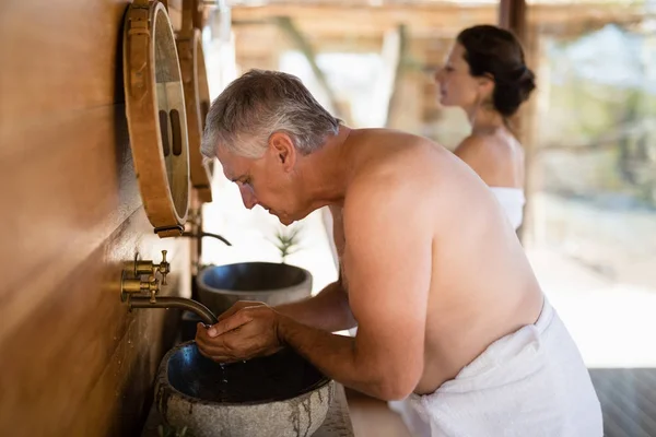 Man gezicht uit het water te wassen in huisje — Stockfoto