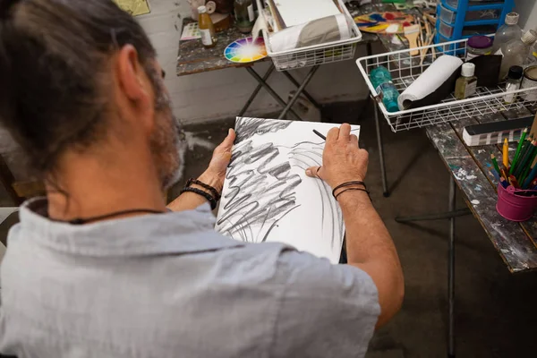 Hombre bosquejando en libro de dibujo — Foto de Stock