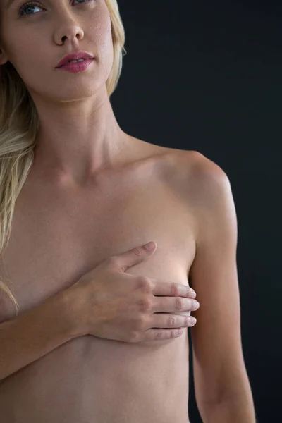 Женщина смотрит в сторону, прикрывая грудь — стоковое фото