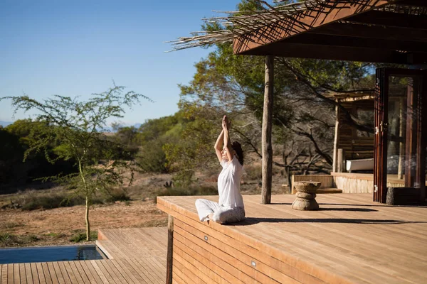 Femme pratiquant le yoga sur planche de bois — Photo