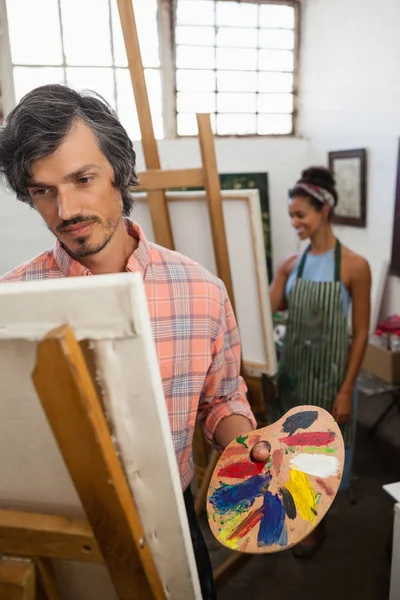 Hombre y mujer pintando sobre lienzo — Foto de Stock