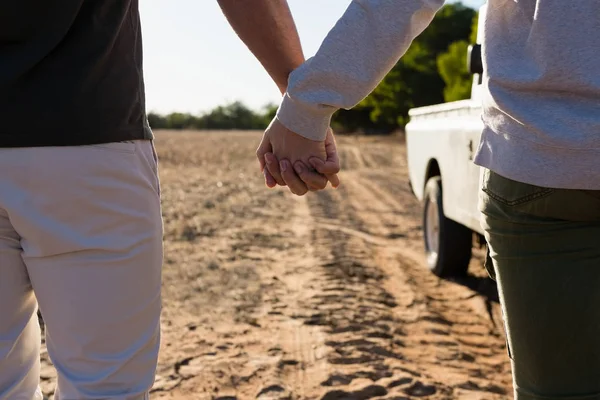 Mid section of couple holding hands — Stock Photo, Image