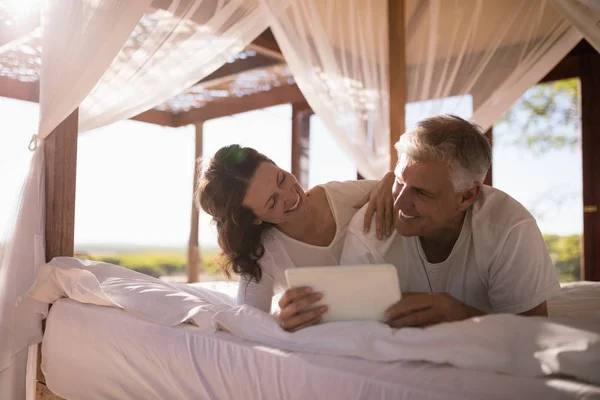 Glückliches Paar mit Tablette im Bett — Stockfoto