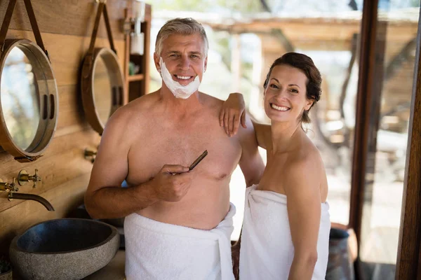 Paar lacht tijdens het scheren in huisje — Stockfoto