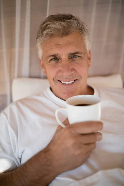 Man har kaffe på säng — Stockfoto