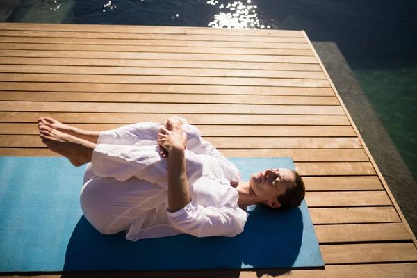 Kvinna som utövar yoga på vid poolen — Stockfoto