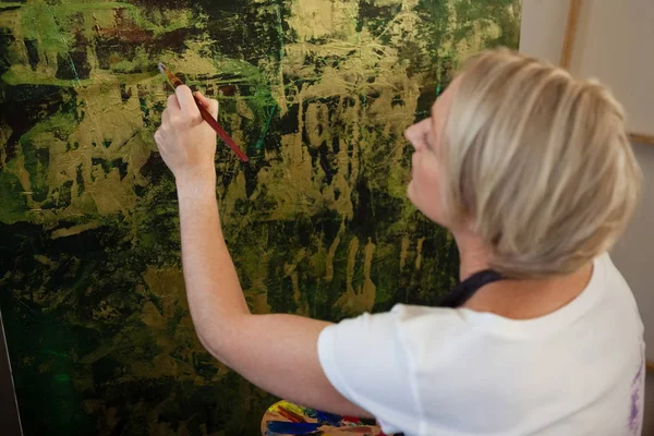 Mulher atenta pintura sobre tela — Fotografia de Stock