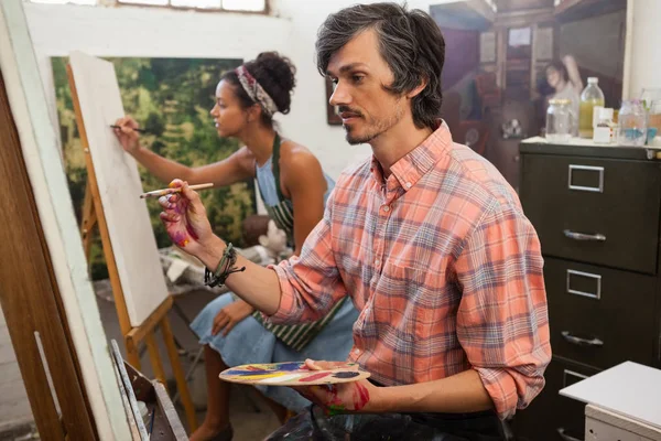 Man and woman painting on canvas — Stock Photo, Image