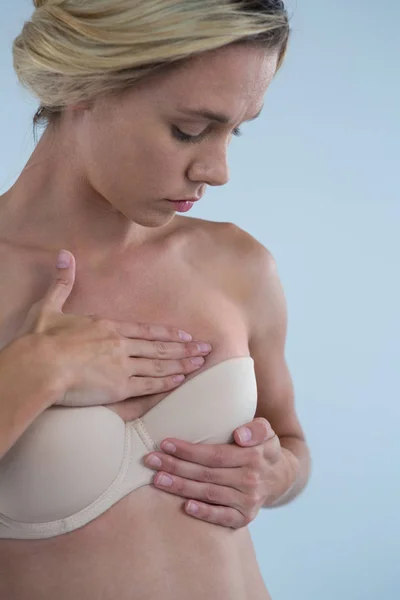 Frau berührt Brust, während sie auf Knoten untersucht — Stockfoto