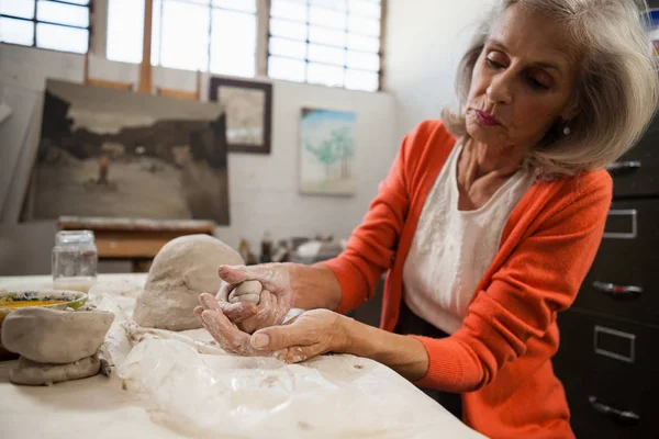 Mujer atenta de edad avanzada arcilla de moldeo — Foto de Stock