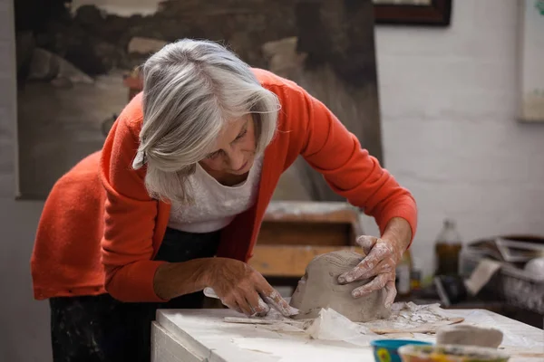 Aufmerksame Seniorin formt geformten Ton — Stockfoto