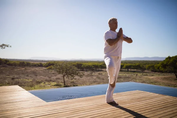 Adam ahşap tahta üzerinde Yoga uygulamak — Stok fotoğraf