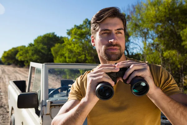 Giovane uomo in possesso di binocolo — Foto Stock