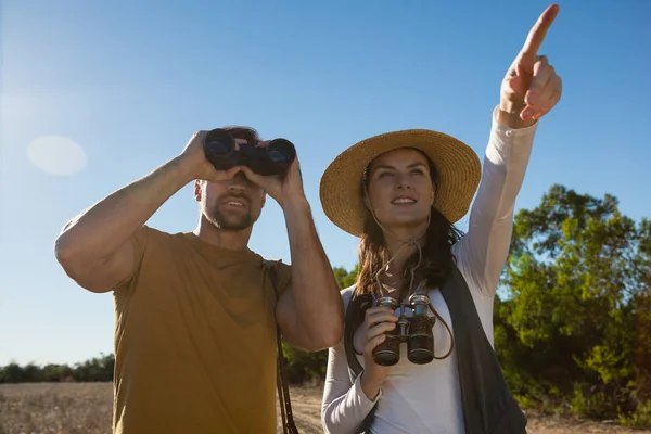 Pareja joven con prismáticos en el bosque —  Fotos de Stock