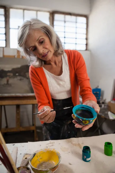 Mujer mayor cuenco de pintura en clase de dibujo — Foto de Stock