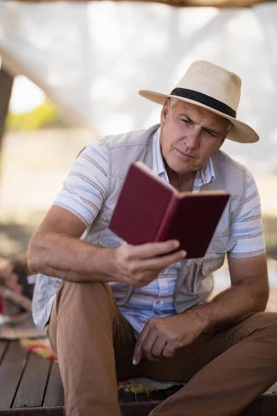 Uprzejmy człowiek czytania książki w domku — Zdjęcie stockowe