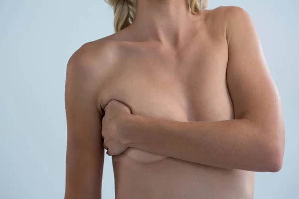 Молодая женщина без рубашки с рукой на груди — стоковое фото