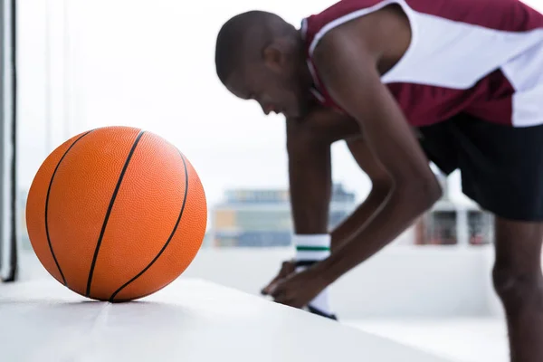 Jogador de basquete amarrando cadarço — Fotografia de Stock