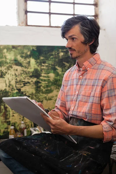 Hombre dibujando un retrato en libro de dibujo — Foto de Stock