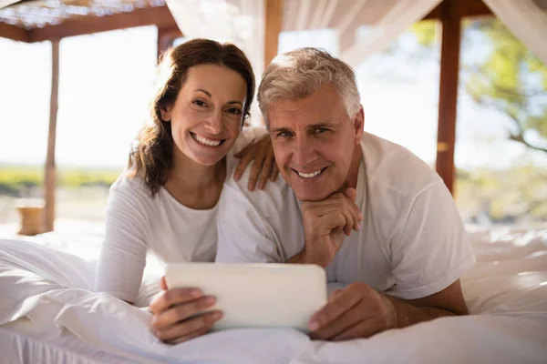 Couple using digital tablet on bed — Stock Photo, Image