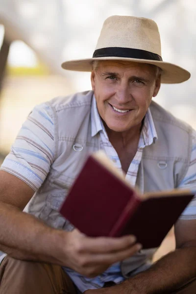 Glücklicher Mann liest Buch im Ferienhaus — Stockfoto