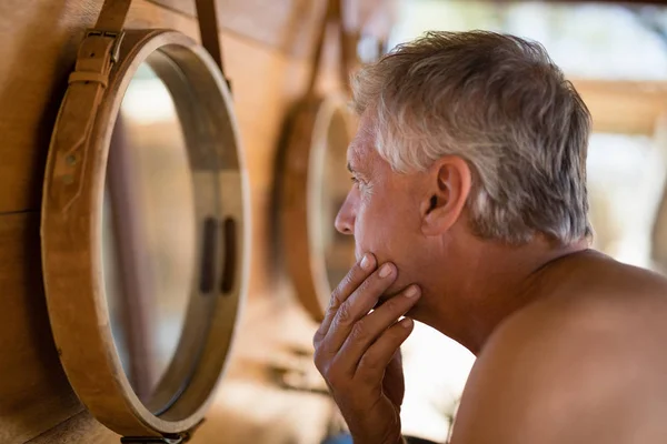 Homme regardant miroir dans le chalet — Photo