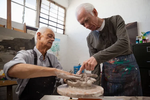 Hombre mayor ayudando en la fabricación de cerámica — Foto de Stock