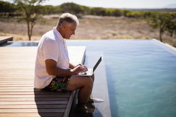 Man använder laptop nära poolen — Stockfoto