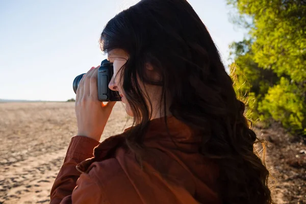 Kvinna som fotograferar från kameran på fältet — Stockfoto