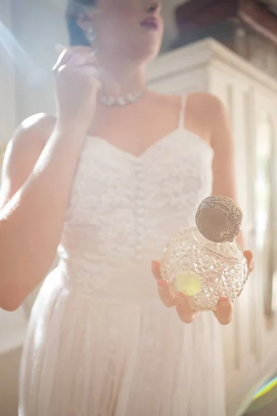 Bruden håller parfym iklädd örhänge — Stockfoto