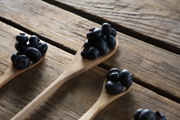 Arándanos en cuchara de madera dispuestos en la mesa — Foto de Stock