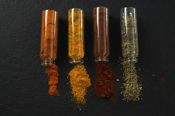 Various spices spilling out of bottles — Stock Photo, Image