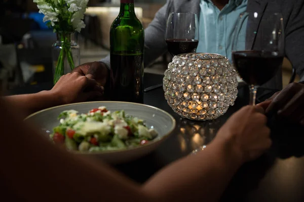 Paar hand in hand tijdens een diner aan tafel — Stockfoto