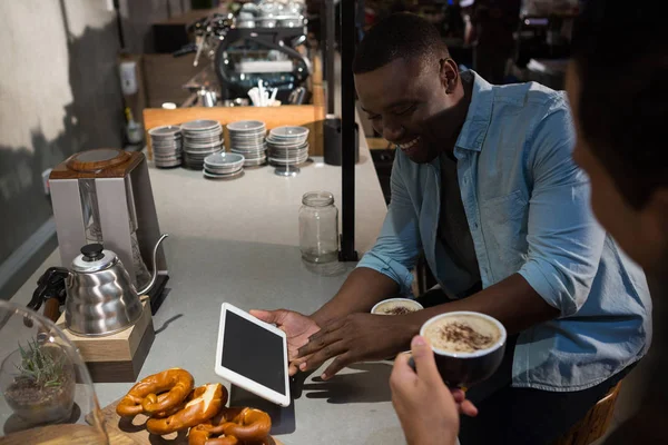 Hombre usando tableta digital mientras toma café — Foto de Stock