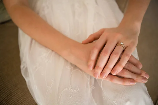 Novia usando anillo de boda mientras está sentado en el sofá —  Fotos de Stock