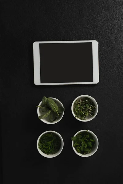 Różne zioła w miskach z tabletem — Zdjęcie stockowe