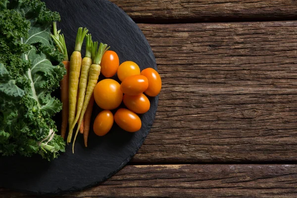 Verduras de mostaza, zanahorias y tomates en bandeja —  Fotos de Stock