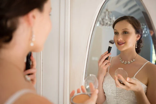 Novia aplicando maquillaje reflejando en espejo — Foto de Stock