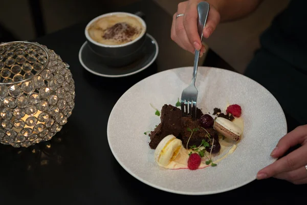 Vrouw met dessert en koffie aan tafel — Stockfoto