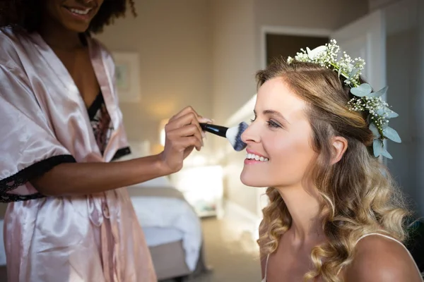 Mujer aplicando maquillaje a la novia — Foto de Stock