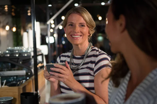 Kvinde interagerer mens du drikker kaffe - Stock-foto
